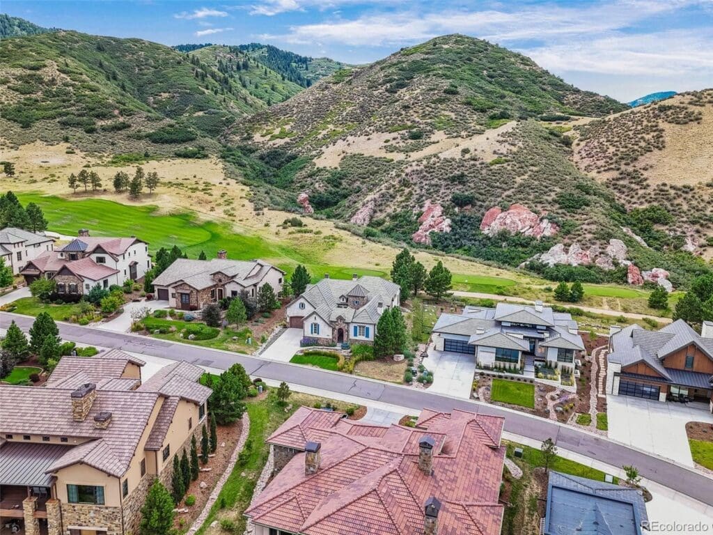 Scenic golf course nestled in a mountainous landscape under a clear blue sky.